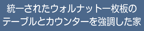 統一されたウォルナット一枚板のテーブルとカウンターを強調した家
